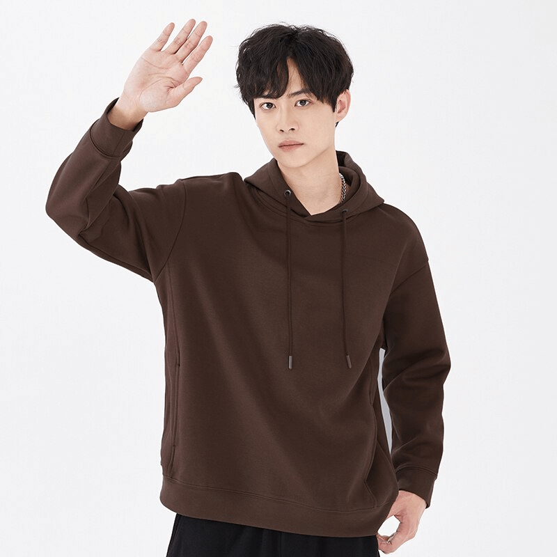 Young man wearing a stylish sporty brown men's hoodie with hood and two pockets, perfect for workouts and active lifestyle.